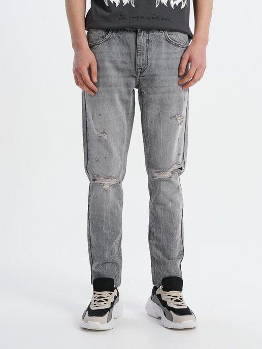 Зауженные джинсы с потертостями на коленках